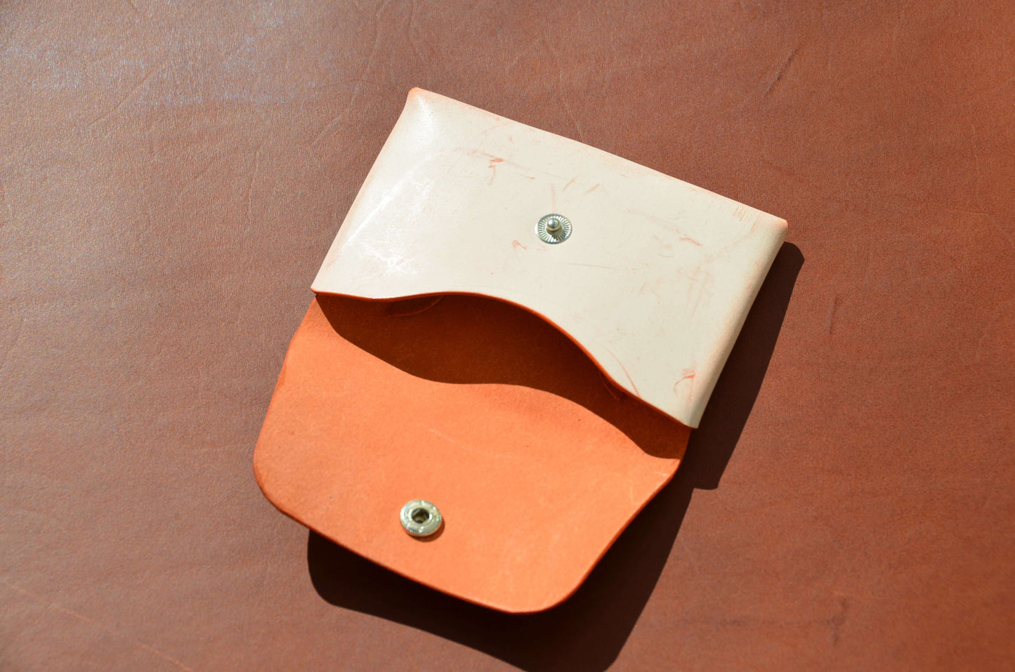 Stitchless Handmade Leather Wallet - Made in USA showing orange interior and cream exterior.