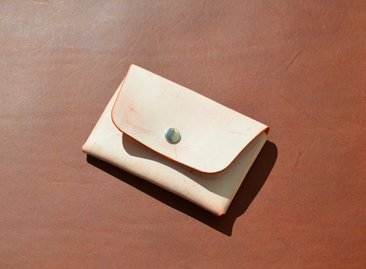 Stitchless Handmade Leather Wallet - Made in USA on orange leather surface.
