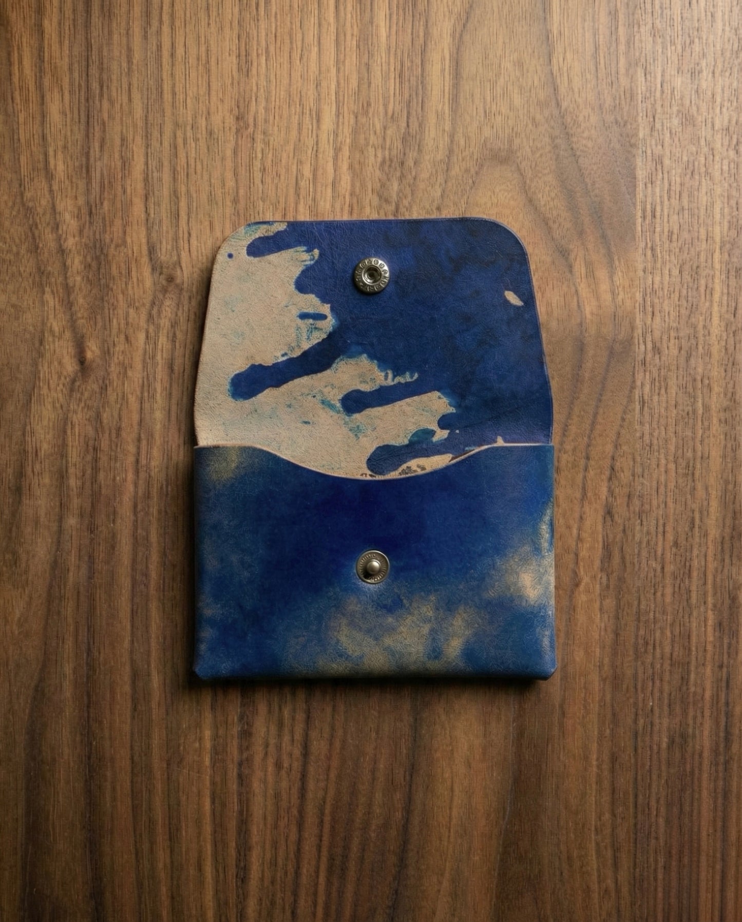 Shell Cordovan Stitchless handmade leather wallet in marbled blue color with snap closure.